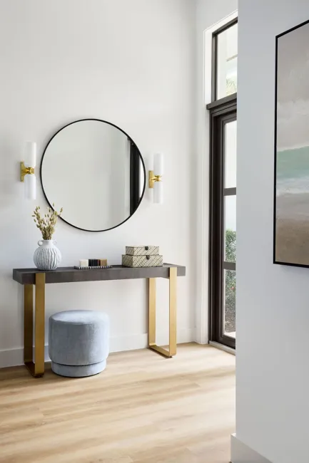 Powder room with stone basin and circular mirror
