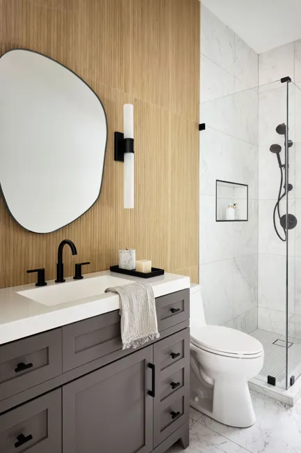 Powder room with wood detailing and circular mirror